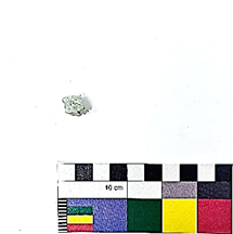 A small rock on a white surface  Description automatically generated