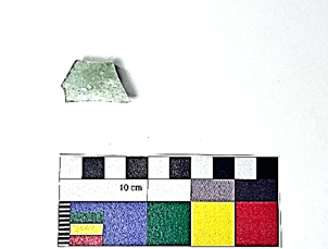 A piece of green stone next to a small rectangular piece of paper  Description automatically generated